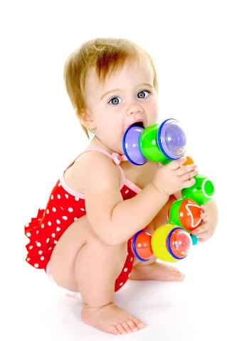 Μωρό που παίζει με πολύχρωμα παιχνίδια